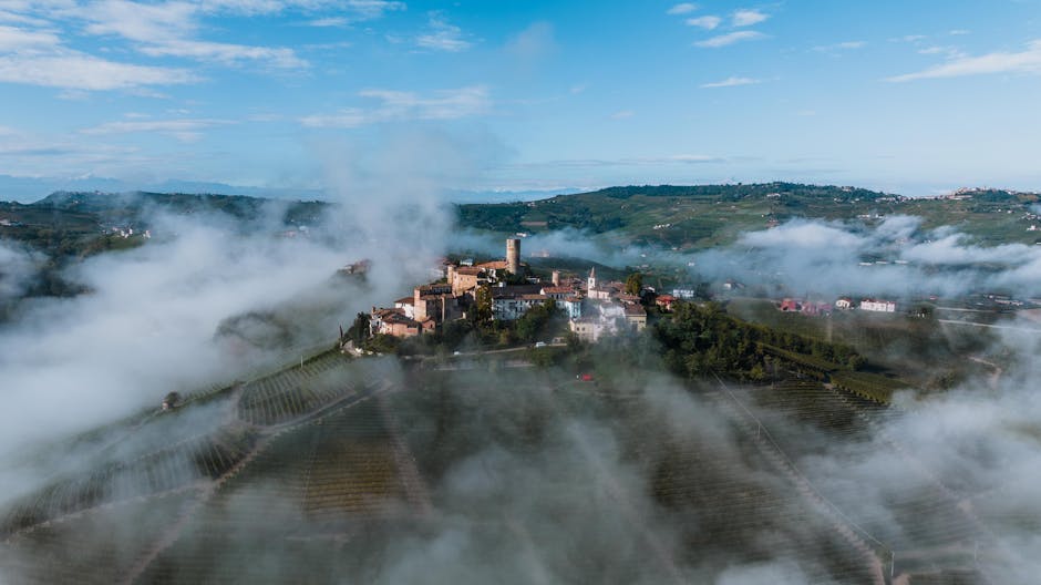 Breathtaking aerial view of Castiglione Falletto wrapped in morning mist.